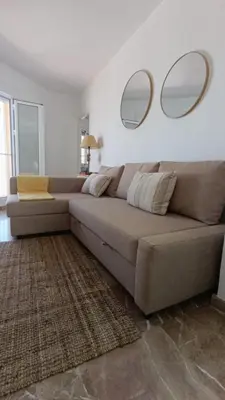 a living room with a couch with two mirrors on the wall at Casa Tuca by 7Escalones in Rota
