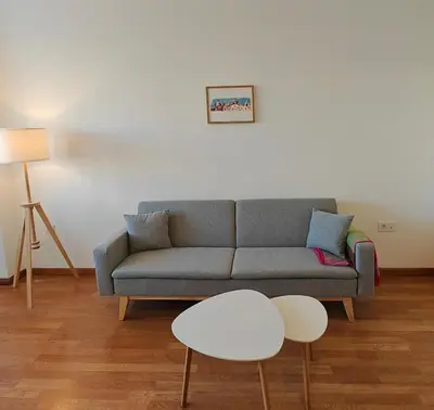 a living room with a gray couch and a white table at El Rincón de la Artista in San Fernando