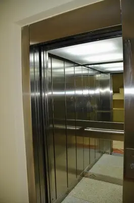a metal elevator door with a reflection in the glass at El Rincón de la Artista in San Fernando