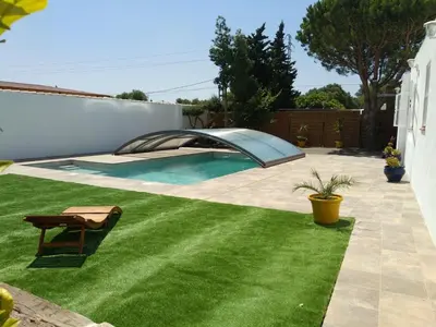 a backyard with a swimming pool and green grass at Countryside villa & private Covered Pool in Chiclana de la Frontera