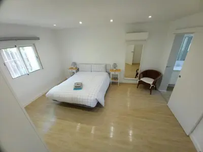 a white bedroom with a bed and a chair at Countryside villa & private Covered Pool in Chiclana de la Frontera