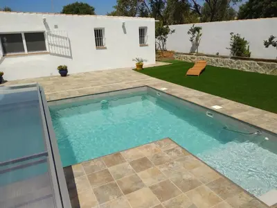 a swimming pool in the backyard of a house at Countryside villa & private Covered Pool in Chiclana de la Frontera