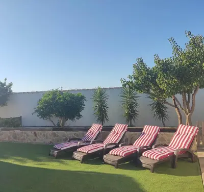 a group of four chairs sitting on the grass at Countryside villa & private Covered Pool in Chiclana de la Frontera