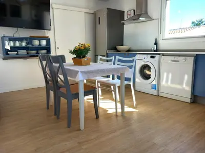 a kitchen with a table and chairs and a washing machine at Countryside villa & private Covered Pool in Chiclana de la Frontera