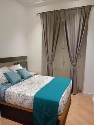 a bedroom with a bed with blue pillows at San juan 32 bajo E in Sanlúcar de Barrameda