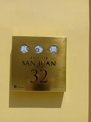 a clock on a wall with the number at San juan 32 bajo E in Sanlúcar de Barrameda