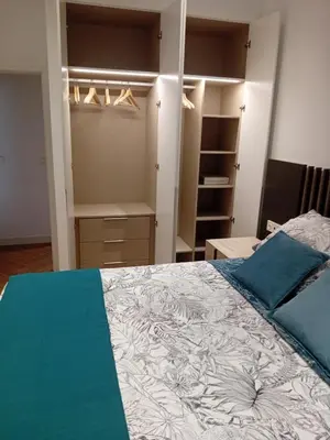 a bedroom with a large bed with blue pillows at San juan 32 bajo E in Sanlúcar de Barrameda