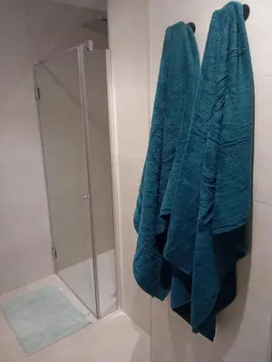a green towel hanging on a wall in a bathroom at San juan 32 bajo E in Sanlúcar de Barrameda