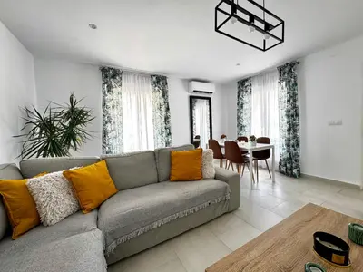 a living room with a couch and a dining room at Apartamento Muñoz Fornell 3 in Chiclana de la Frontera