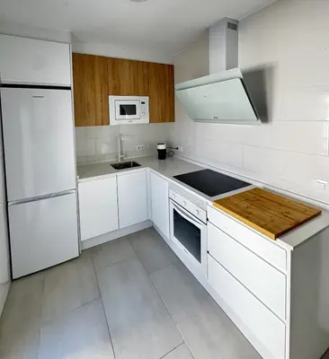 a white kitchen with white cabinets and a sink at Apartamento Muñoz Fornell 3 in Chiclana de la Frontera