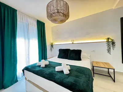 a bedroom with a large bed with towels on it at Apartamento Muñoz Fornell 3 in Chiclana de la Frontera