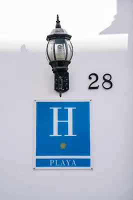 a sign with a light on the side of a building at HOTEL Paquita in Chipiona
