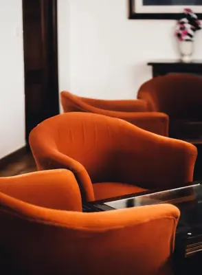 a row of orange chairs in a room at HOTEL Paquita in Chipiona