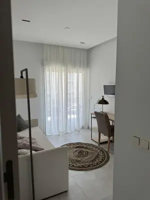 a white bedroom with a bed and a dining room at Oasis Ballena Exclusive in Cádiz