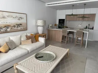 a living room with a white couch and a kitchen at Oasis Ballena Exclusive in Cádiz