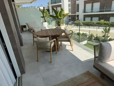 a patio with a wooden table and chairs on a balcony at Oasis Ballena Exclusive in Cádiz