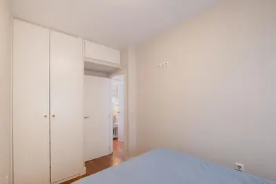 a white bedroom with white cabinets and a bed at Pez Austral in Cádiz