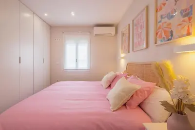 a bedroom with a bed with pink sheets and pillows at Pez Austral in Cádiz