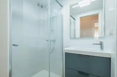 a white bathroom with a sink and a shower at Pez Austral in Cádiz
