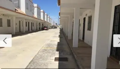 an empty street with a row of white buildings at Playasol in Chiclana de la Frontera