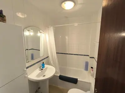 a bathroom with a sink and a bath tub at Playasol in Chiclana de la Frontera