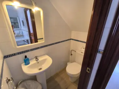 a small bathroom with a sink and a toilet at Playasol in Chiclana de la Frontera