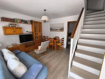 a living room with a blue couch and a staircase at Playasol in Chiclana de la Frontera