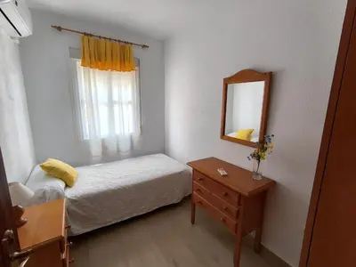 a bedroom with a bed and a mirror and a dresser at Playasol in Chiclana de la Frontera