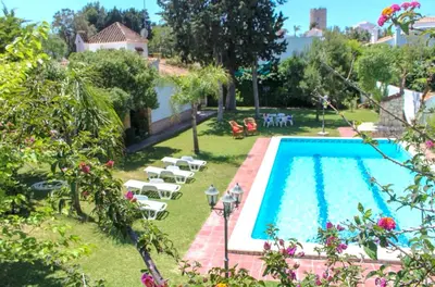 a swimming pool in a yard with lounge chairs and a pool at Villa Las Cármenes in Conil de la Frontera