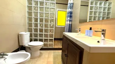 a bathroom with a sink and a toilet and a mirror at Villa Las Cármenes in Conil de la Frontera