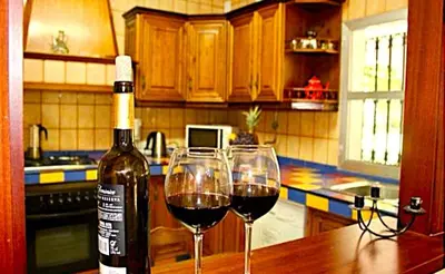 a bottle of wine and two wine glasses on a table at Villa Las Cármenes in Conil de la Frontera