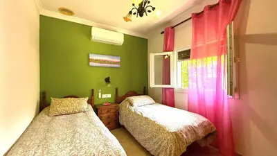 a bedroom with two beds and a window at Villa Las Cármenes in Conil de la Frontera