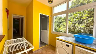 a kitchen with yellow walls and a window at Villa Las Cármenes in Conil de la Frontera