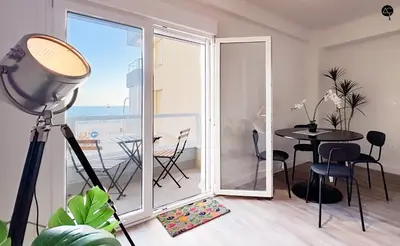a room with a balcony with a table and a view of the ocean at En la Orilla del Mar Grupo AC Gestion in Cádiz