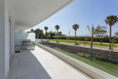a balcony with a table and a view of a street at Ocean Costa Ballena in Chipiona