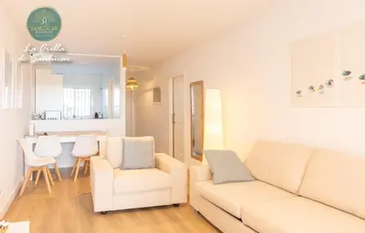a living room with a white couch and two chairs at La Orilla by Sanlucar Housing in Sanlúcar de Barrameda