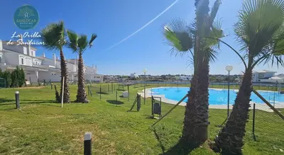a group of palm trees next to a swimming pool at La Orilla by Sanlucar Housing in Sanlúcar de Barrameda