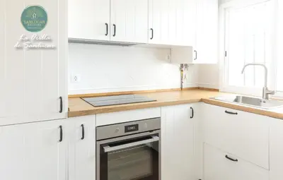 a white kitchen with white cabinets and a sink at La Orilla by Sanlucar Housing in Sanlúcar de Barrameda