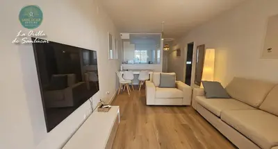 a living room with a couch and a tv at La Orilla by Sanlucar Housing in Sanlúcar de Barrameda