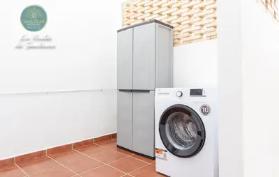 a washing machine in a room next to a wall at La Orilla by Sanlucar Housing in Sanlúcar de Barrameda