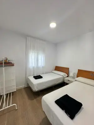 a small room with two beds and a window at Casa Adaro in Conil de la Frontera