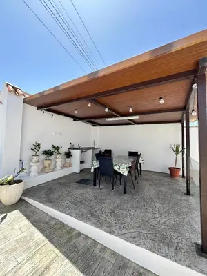 a patio with awning and a table and chairs at Casa Adaro in Conil de la Frontera