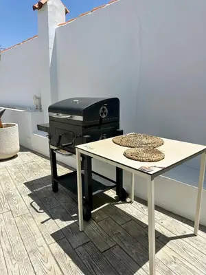 a table with a grill and a table with hats on it at Casa Adaro in Conil de la Frontera