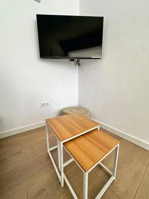 a room with a table with a television on the wall at Casa Adaro in Conil de la Frontera