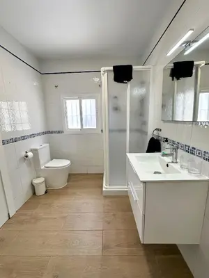 a bathroom with a toilet and a sink and a shower at Casa Adaro in Conil de la Frontera
