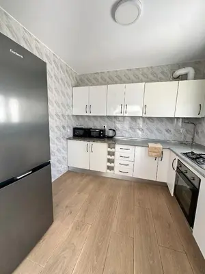 a kitchen with white cabinets and a stainless steel refrigerator at Casa Adaro in Conil de la Frontera