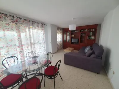 a living room with a glass table and chairs at Timonel Arenas in El Puerto de Santa María