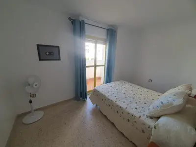a bedroom with a bed and a window with a fan at Timonel Arenas in El Puerto de Santa María