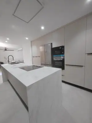 a white kitchen with a large white counter top at Casa Isabel 29 in Chipiona