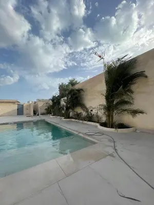a swimming pool with palm trees next to a building at Casa Isabel 29 in Chipiona